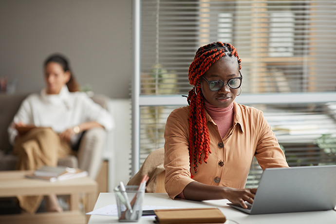 Red braids woman typing on computer